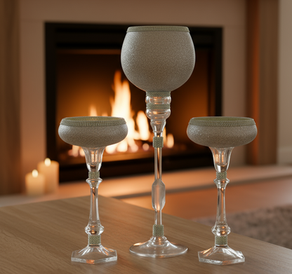 Set of three decorative glass vases on a table with a blurred indoor background
