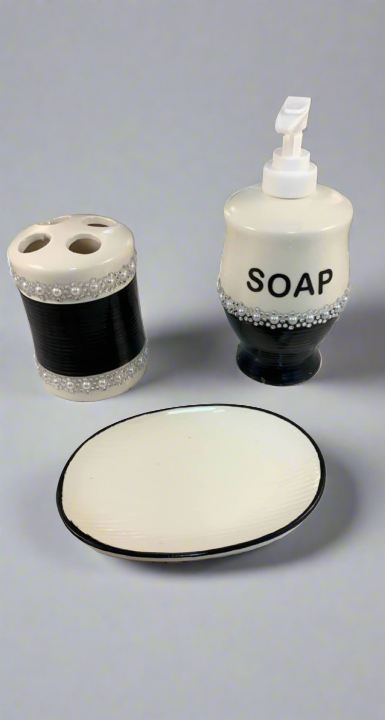 Bathroom accessory set with a soap dispenser, toothbrush holder, and soap dish on a gray background.