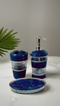 Bathroom accessory set with blue and clear design on a white surface